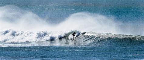 Surfer at Wainui Beach, north of Gisborne, on the East Coast of New Zealand. | Surfing, East ...