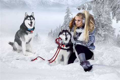 Beautiful Blonde Woman, Standing on Snow and Holding Husky Dogs View of ...