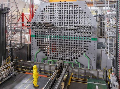 a man in yellow is standing next to a machine