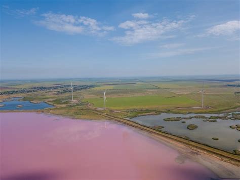 Premium Photo | Amazing aerial view of windmills near the pink lake