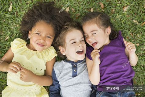 Children lying on the grass and laughing — preschooler, playing - Stock Photo | #124202434