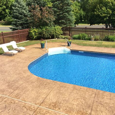 Stamped and colored concrete pool deck with custom chiseled stone cantilevered coping by Sierra ...