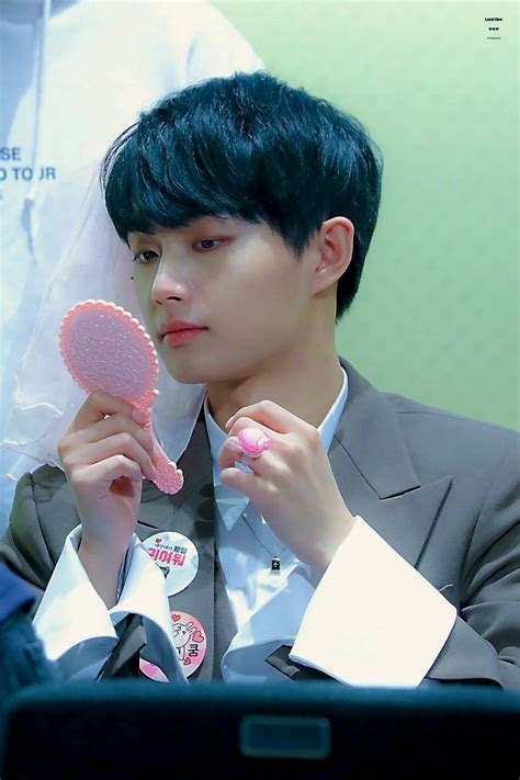 a young man holding a pink heart shaped object