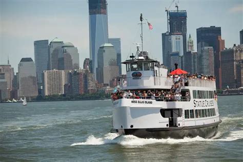 A Statue Cruise in front of the Manhattan skyline.