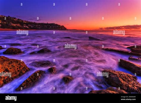 Bright colourful sunrise over Pacific ocean horizon at Whale beach of Sydney Northern beaches ...