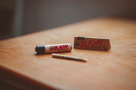 Roll up cigarette and lighter placed on table · Free Stock Photo