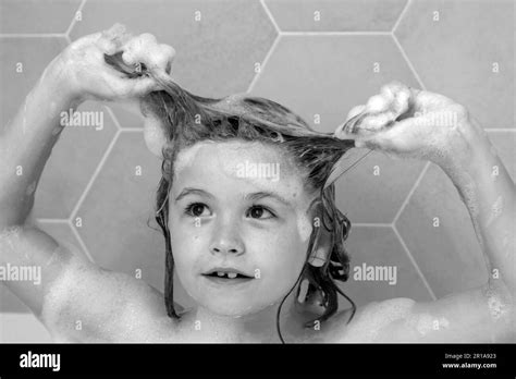 Kid washing hair. Soap on child head. Child face in foam. Kid bathing in a bath with foam. Funny ...
