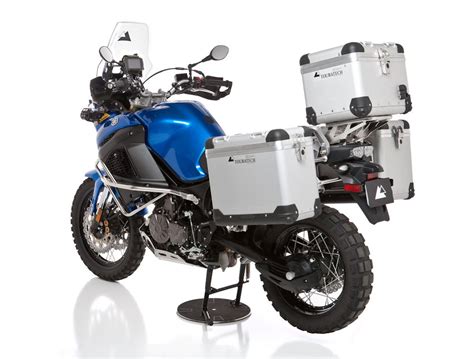 a blue and white motorcycle with luggage on it's back tire, parked in ...