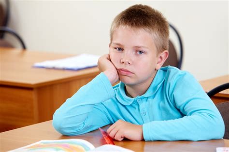 Bored little boy at his desk Photo | Free Download