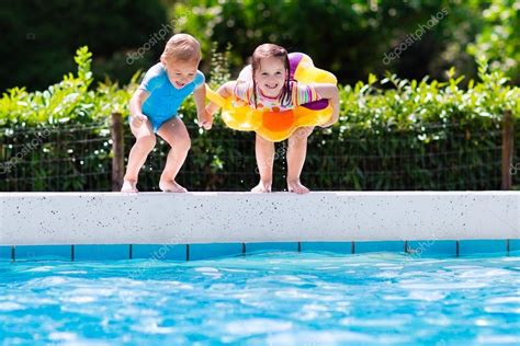 Kids jumping into swimming pool — Stock Photo © FamVeldman #119829738