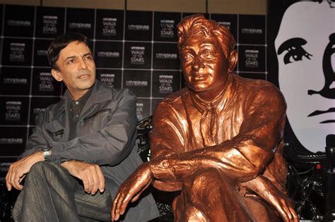 Dev Anand s son Suneil Anand posing with the brass statue of his late father 2 : rediff ...