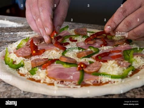 Putting ingredients on pizza Stock Photo - Alamy