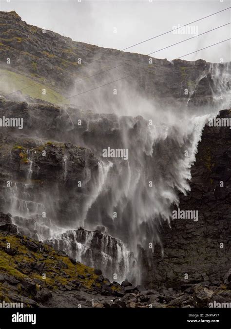 Close up for waterfall Fossa (Fossá) during strong wind in rainy weather, Streymoy Island, Faroe ...