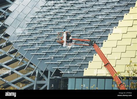 HANGZHOU, CHINA - APRIL 6, 2021 - Construction workers install the facade of the Hangzhou Asian ...