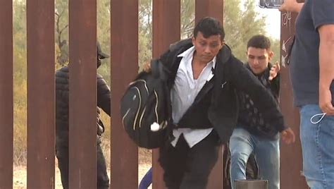 WATCH: Dozens of migrants breach border wall, take selfies on US side ...