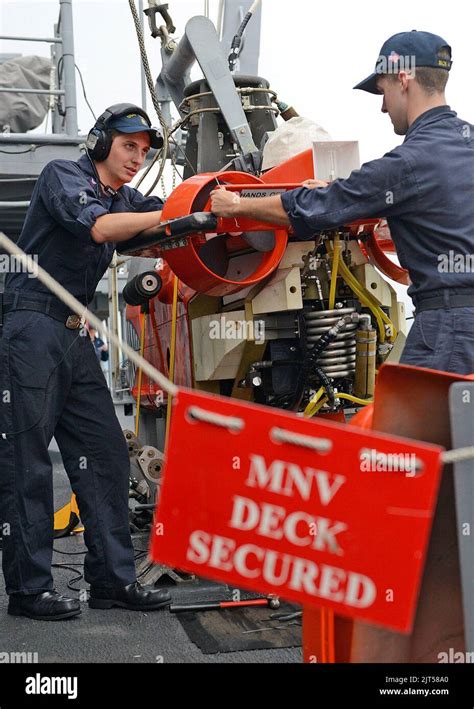 U.S. Navy Mineman 2nd Class left, and Mineman perform maintenance on a mine neutralization ...