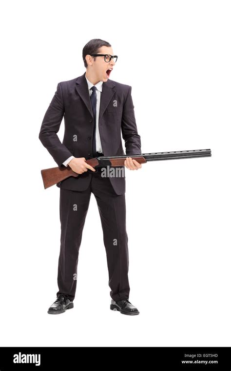 Full length portrait of an angry man holding a rifle and shouting ...