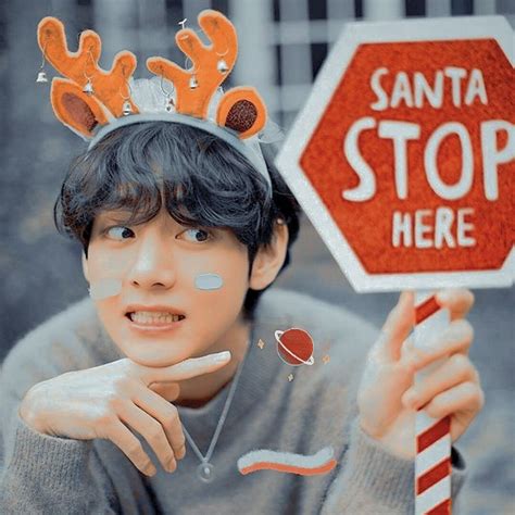 a young man holding up a stop sign with reindeer antlers on it's head