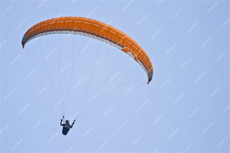 Free Photo | Amazing shot of a human paragliding on blue sky