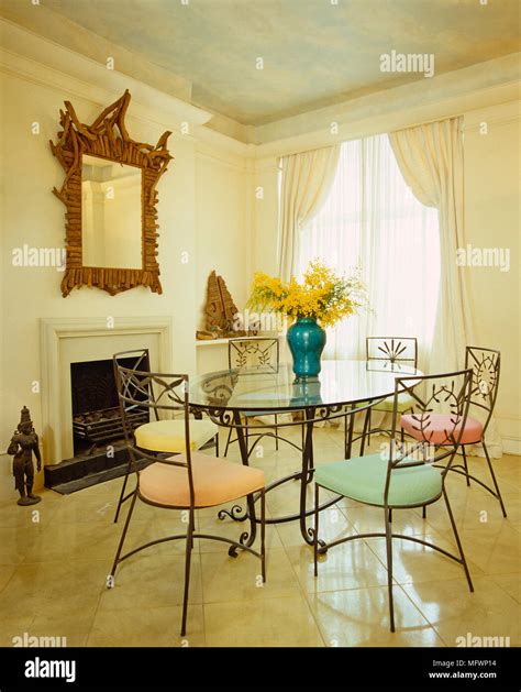 Round glass dining table with metal chairs Stock Photo - Alamy