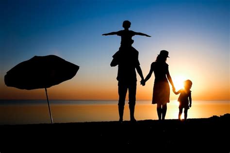 Premium Photo | A happy family by the sea at sunset in travel ...