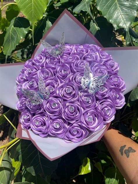 a bouquet of purple roses with butterflies on them