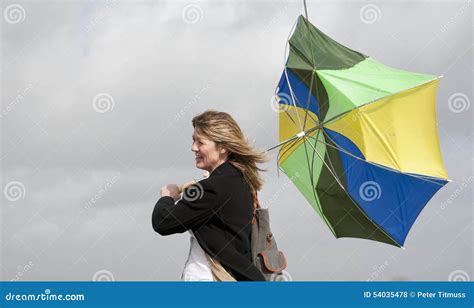 Woman Struggling To Hold Her Umbrella On A Windy Day Stock Photo - Image: 54035478