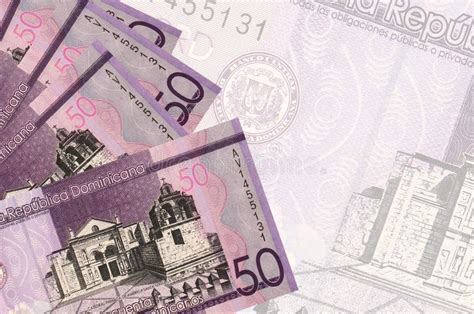 50 Dominican Pesos Bills Lies in Stack on Background of Big Semi-transparent Banknote. Abstract ...