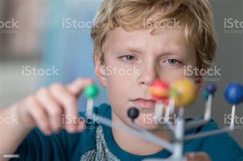 Focused Preteen School Boy Examines Solar System Model Stock Photo - Download Image Now - iStock