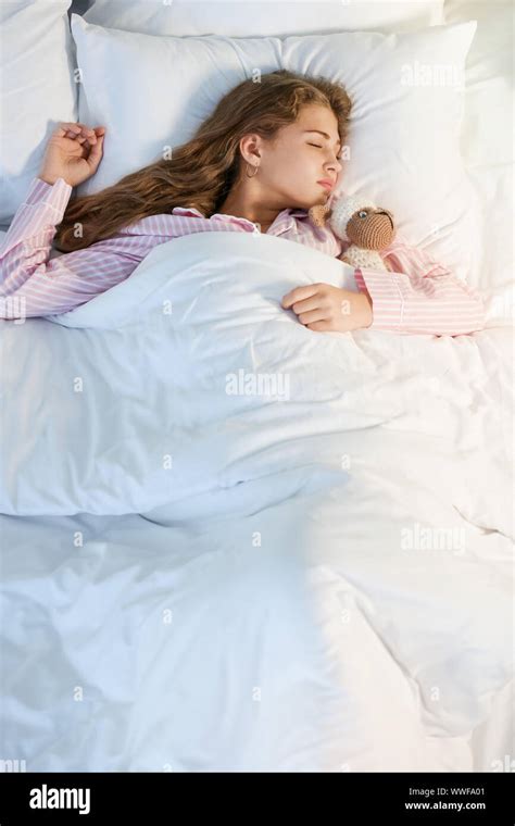 Teenage girl sleeping in bed at night Stock Photo - Alamy