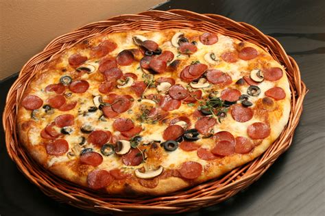 Italian pizza with pepperoni, black olives and mushrooms. Baked in an electric stone oven at 400 ...