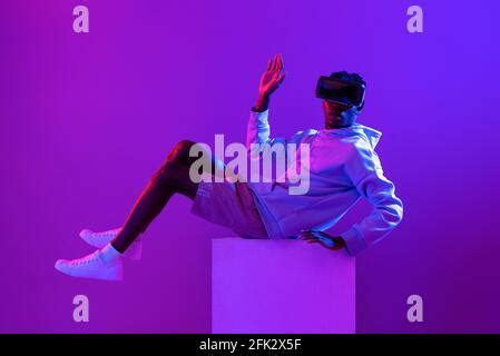 Cyberpunk. A man in futuristic glasses looks at the night sky. Night neon city Stock Photo - Alamy