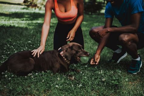 Premium Photo | Handsome black man walking brown dog in park