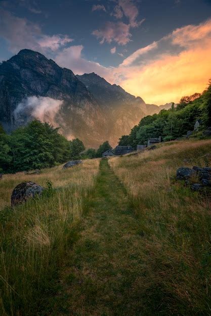 Premium Photo | A green hiking trail during a sunset between mountains