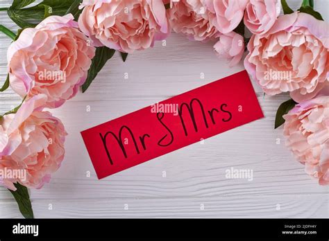 Red paper with mr and ms handwriting on white desk. Frame of pink peony flowers Stock Photo - Alamy