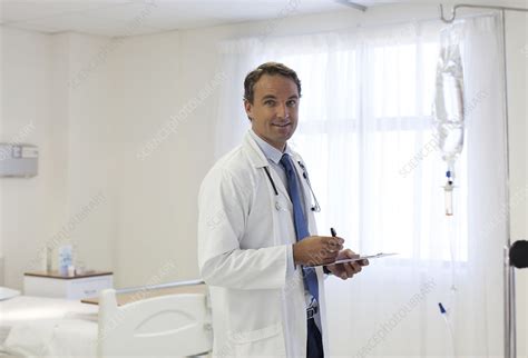 Doctor writing on clipboard in hospital - Stock Image - F013/9029 - Science Photo Library