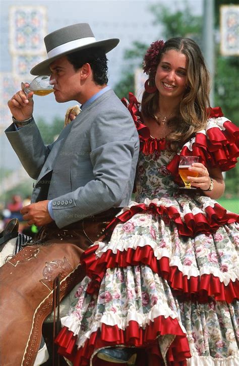 a man and woman dressed in period clothing sitting on top of a horse ...