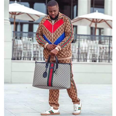 a man holding a guccini bag and standing on the sidewalk with his hands ...