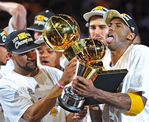 Kobe Bryant with all his trophies | HoopsHype