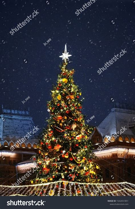 Christmas Tree in Festive decor and Illumination in snowy night. New Year and Christmas ...