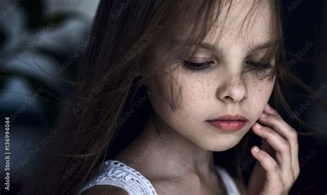 Sad little girl with tears on pretty face is crying indoors. Stock-Foto | Adobe Stock