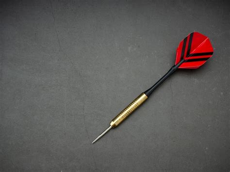 Premium Photo | Dart arrow with board on black granite