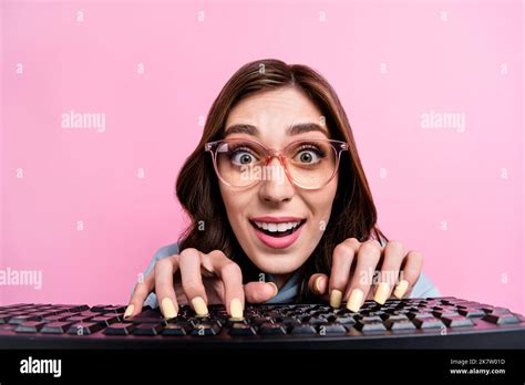 Portrait of cheerful amazed lady toothy smile fingers typing keyboard isolated on pink color ...