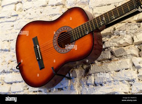 Common Guitar On White Brick Wall Stock Photo - Alamy
