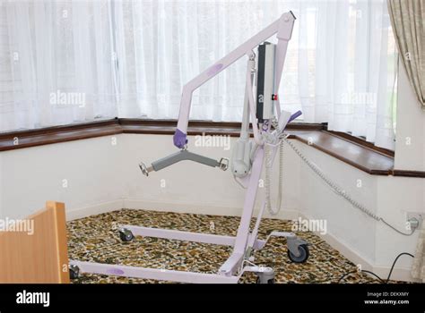 A free standing electric hoist for helping a patient get out of bed. Disability equipment for a ...