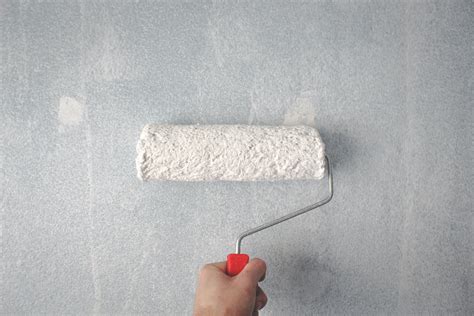 Person Holding Paint Roller On Wall · Free Stock Photo