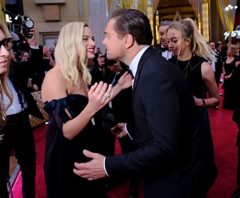 Margot Robbie hugs ex co-star Leonardo DiCaprio in touchy-feely reunion as her husband looks on ...