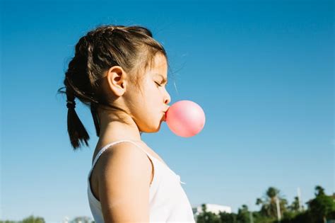 Cute girl blowing bubble gum | Free Photo