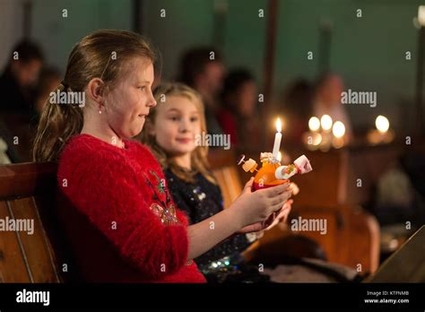 Two young girls hold Christingle oranges at a Christmas church service, UK Stock Photo - Alamy