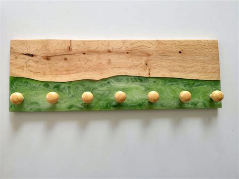 a piece of art made out of wood and green material with yellow balls on it